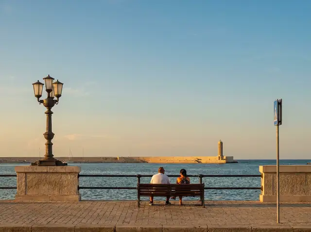 A retired couple sitting on the Bari seafront